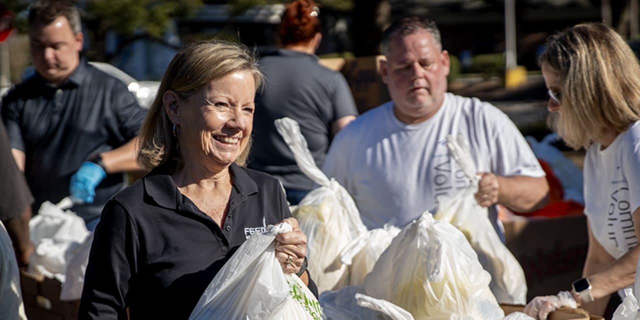 volunteers passing out plastic grocery bags of food