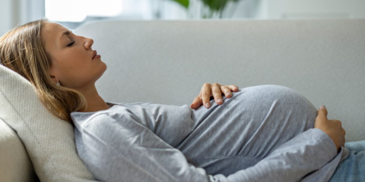 A pregnant woman lying on a couch