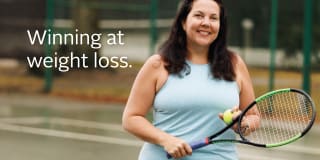 A woman who finally found a long-term weight loss solution with bariatric surgery stands on a tennis court holding a ball and racquet while smiling. Text reads "Winning at weight loss"