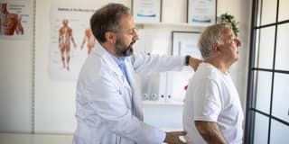 doctor examining a man's spine