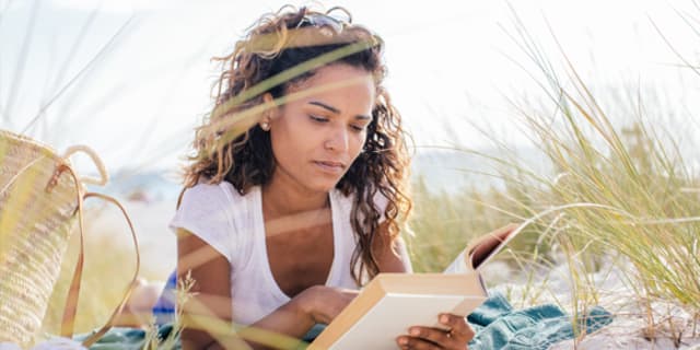 woman reading at the beach