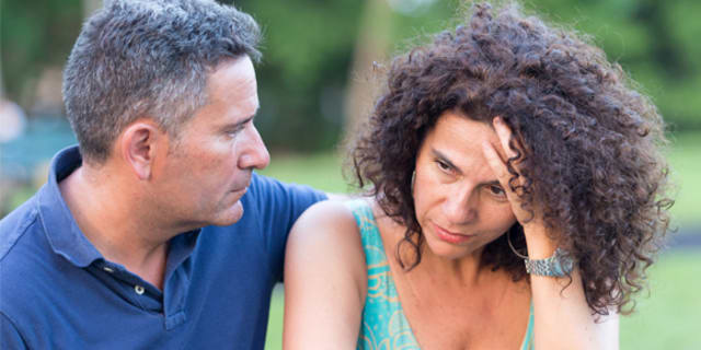 A frustrated woman is comforted by her male partner