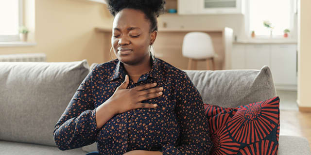 A woman clutching her chest like she is having heart palpitations