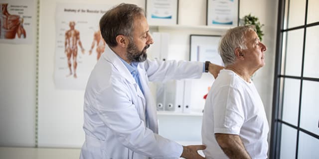 doctor examining a man's spine