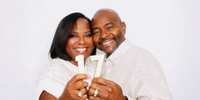 Greg and Lakesha Burton holding sign 17 for their anniversary.