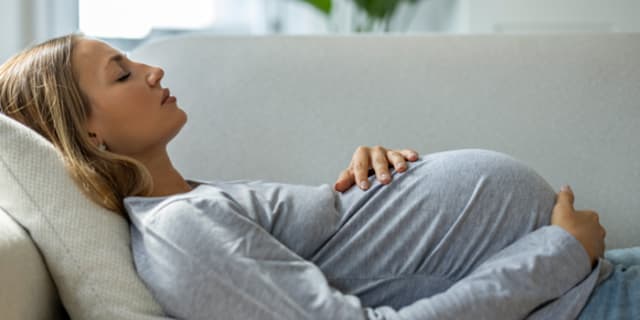 A pregnant woman lying on a couch