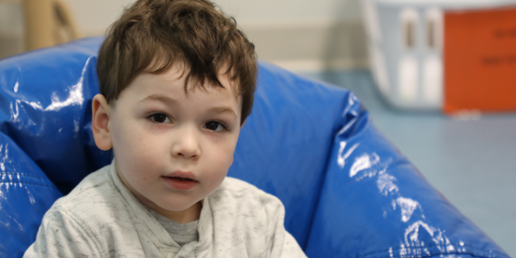 photo of a male toddler sitting on a blue bean bag chair