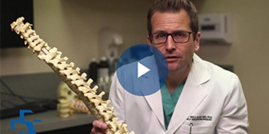 spinal surgeon with model lumbar