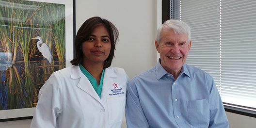 photo of patient Joe Cawley and Ruby Satpathy, MD, interventional cardiologist, sitting in an office