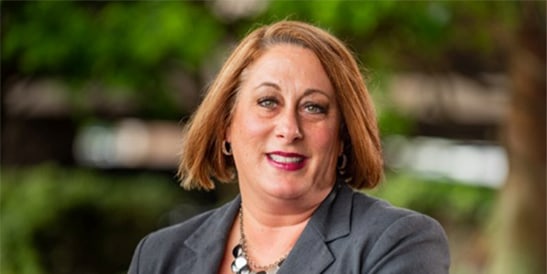 photo of patient Kelly Sands smiling against a blurred outdoor background