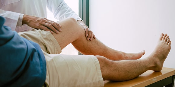 doctor with his hands on a male patient's knee
