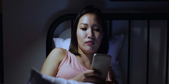 woman looking at her phone screen in the dark