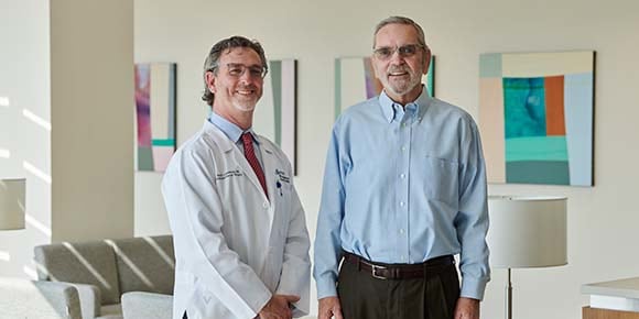 John Jones stands smiling with Dr. Ron Landmann