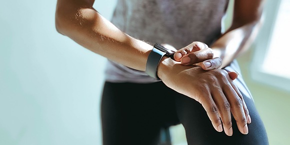 a close up photo of a man tapping his smart watch on his wrist.