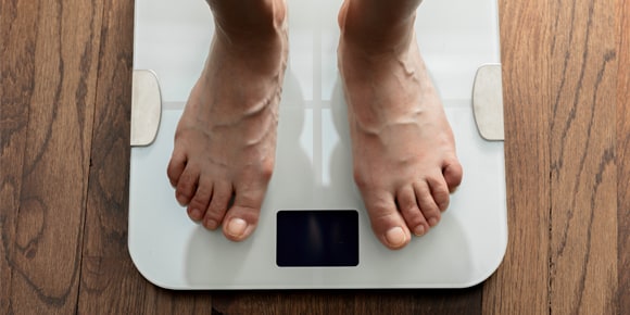 feet on a scale depicting weight loss