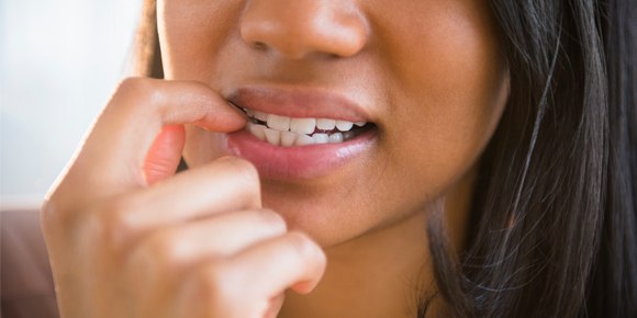 close up of woman biting her nails