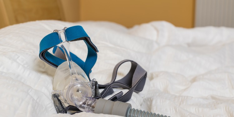 cpap mouthpiece and head strap with tubing on a pillow