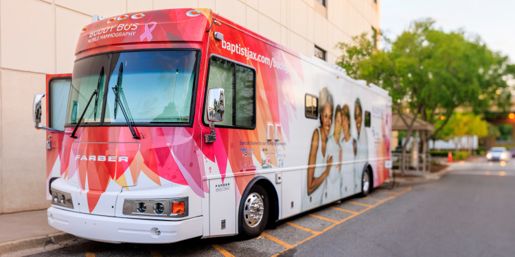 mobile mammography bus (buddy bus) parked outside of a building in bright sunlight