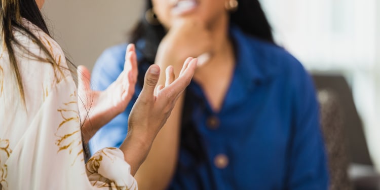 Photo of a clinic setting where a female therapist is listening to a female patient