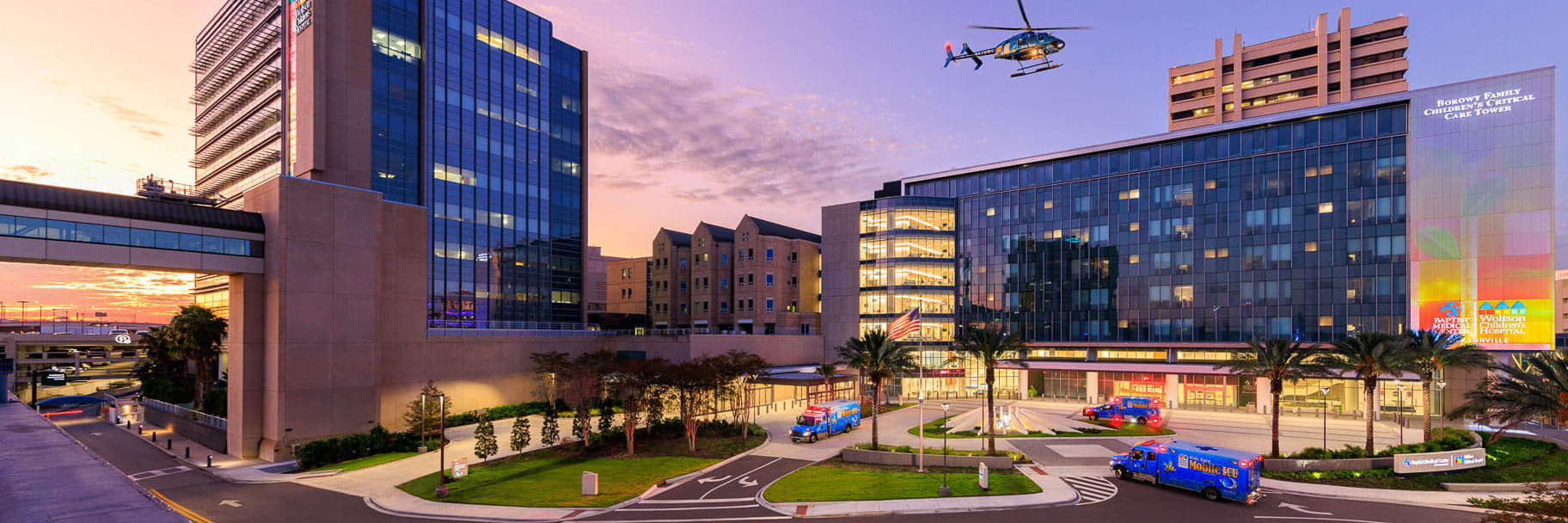 exterior of Wolfson Children's hospital and Borowy Family Critical Care Tower in the evening with Kids Kare helicopter flying over