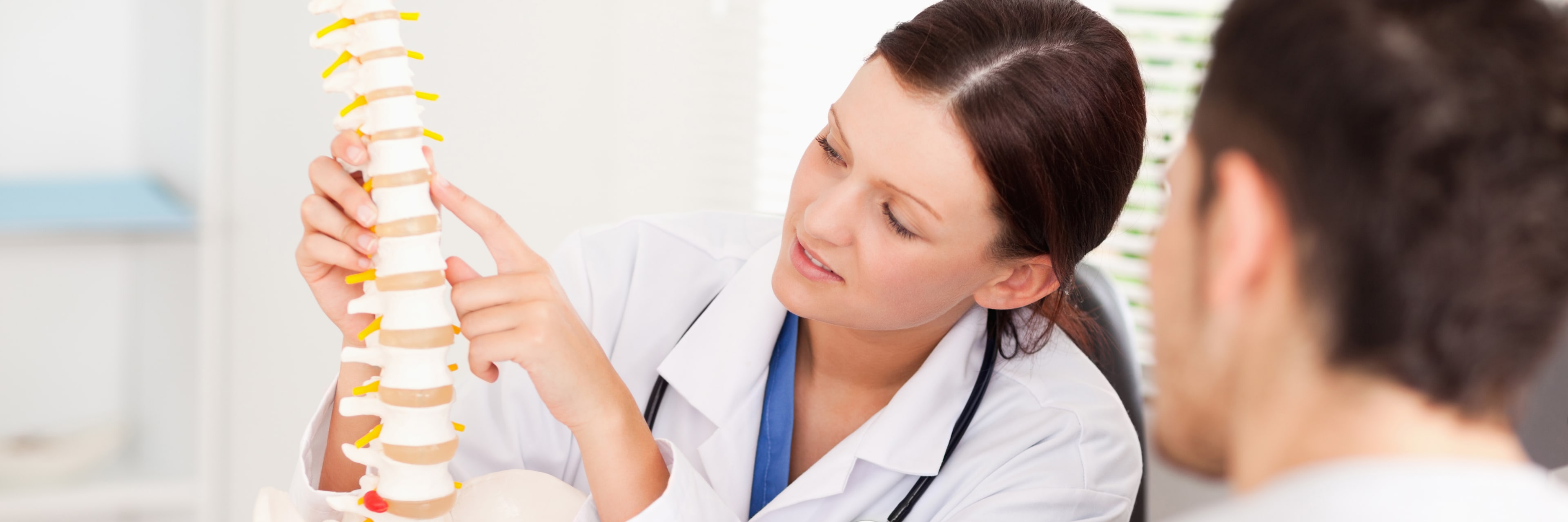 female doctor pointing on bone in spine