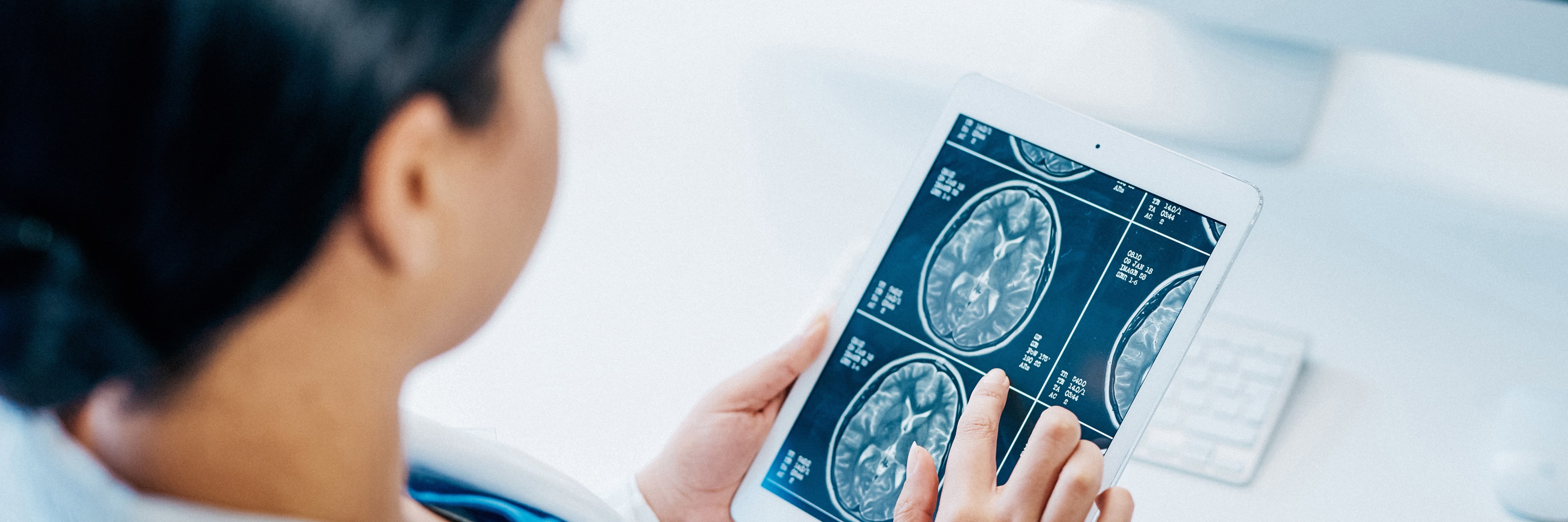 Woman looking at tablet of brain scans