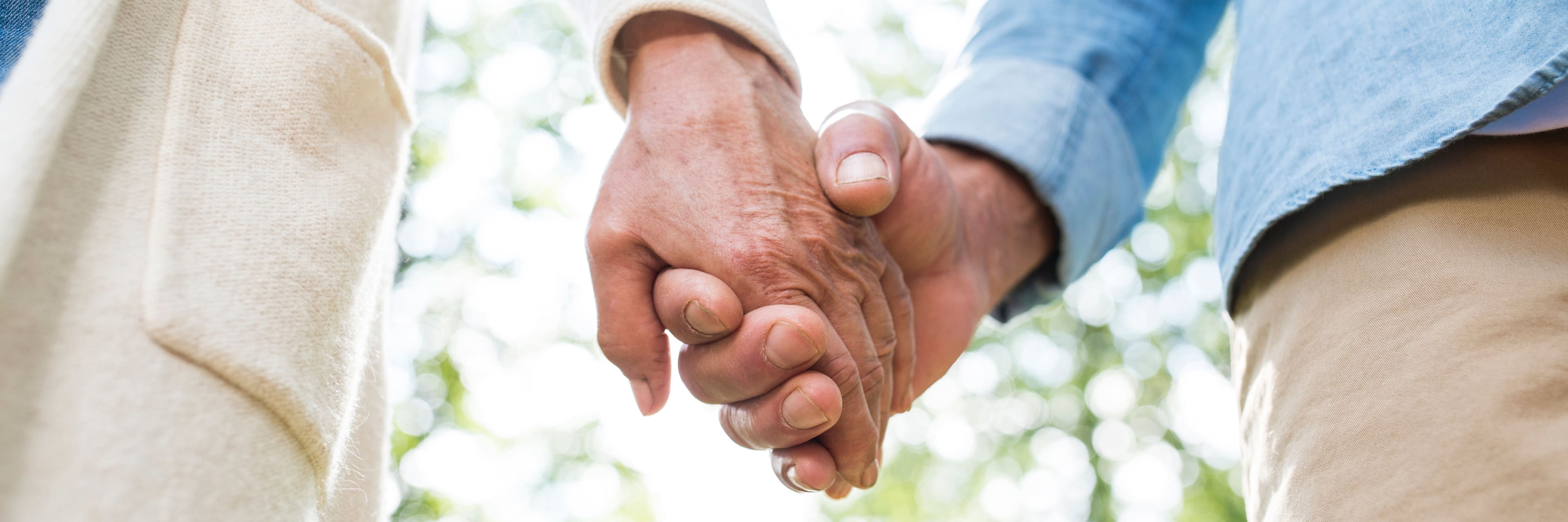 close up of senior couple holding hands