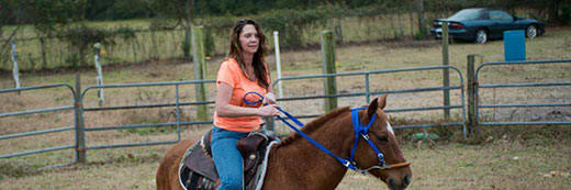 Woman riding a horse at a ranch