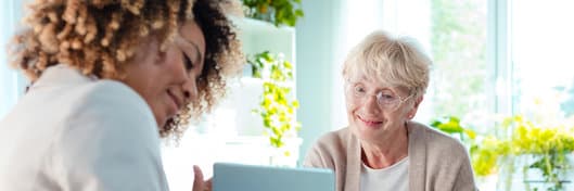 Smiling senior woman talking with healthy living coach.