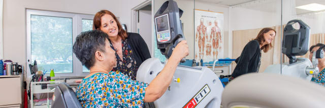 patient on machine with her therapist