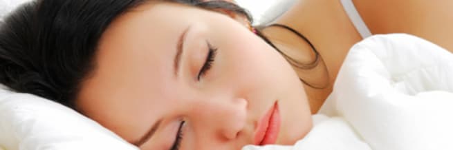 close up of woman sleeping on white sheets