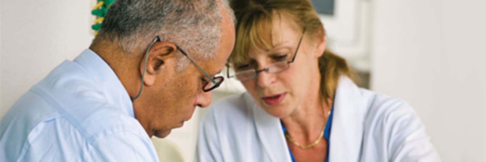 man and woman wearing glasses looking down examining something together