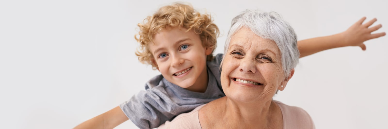 smiling woman giving her grandson a piggyback ride