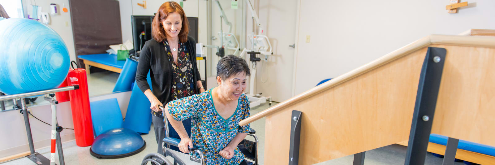 therapist helping a woman in wheelchair with her therapy