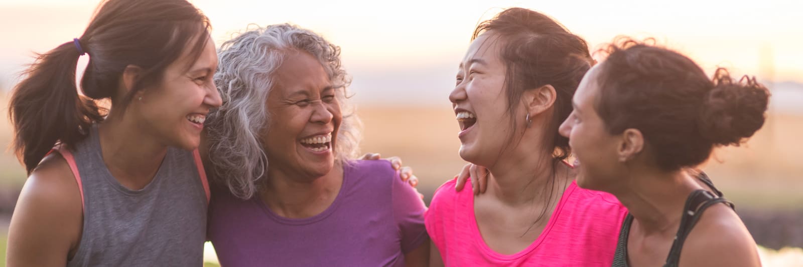 group of four women laughing together