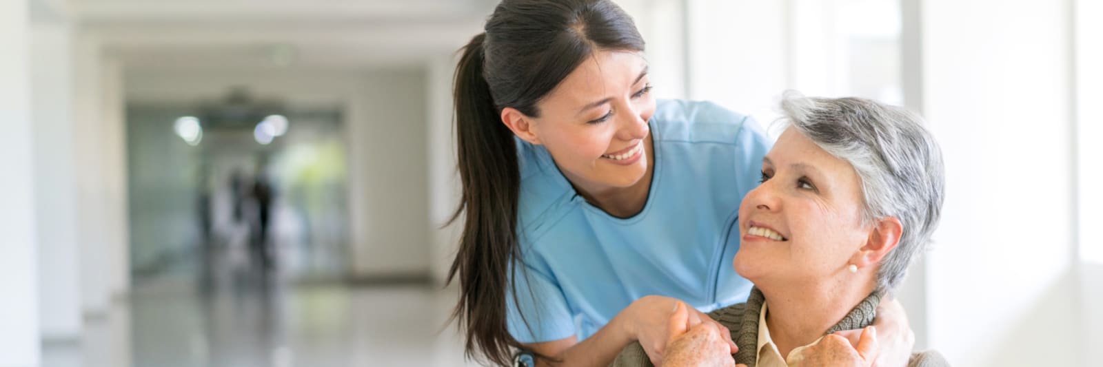 medical worker smiling with a woman in a wheelchair