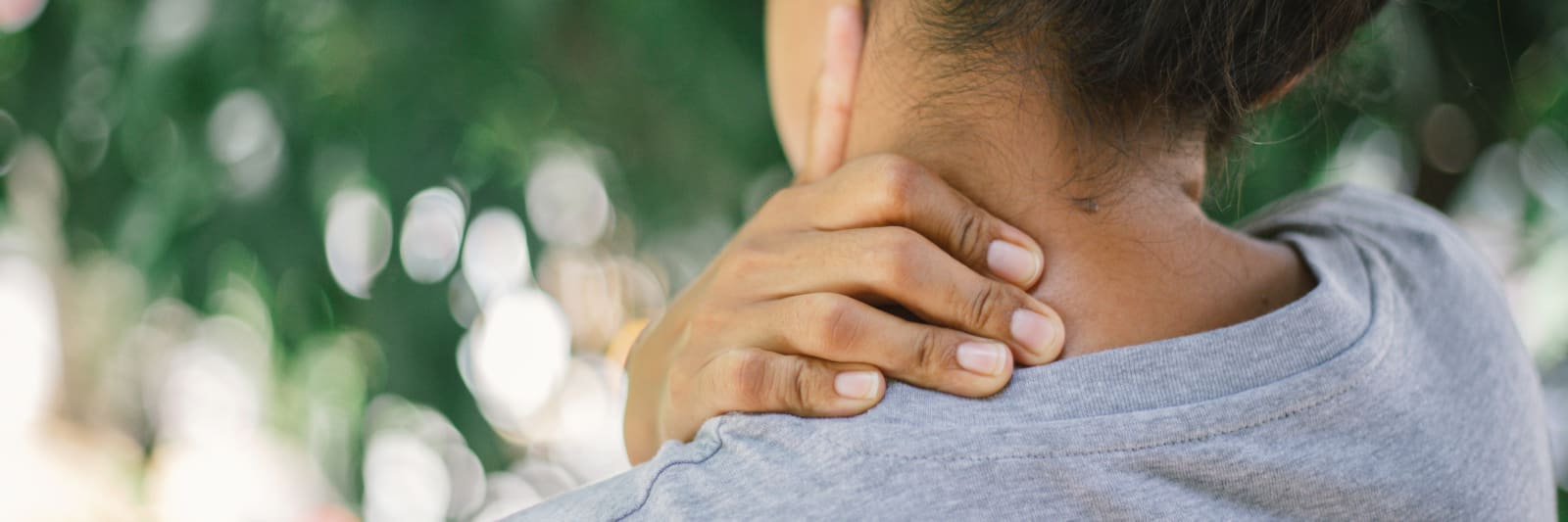 woman with her hand on her neck