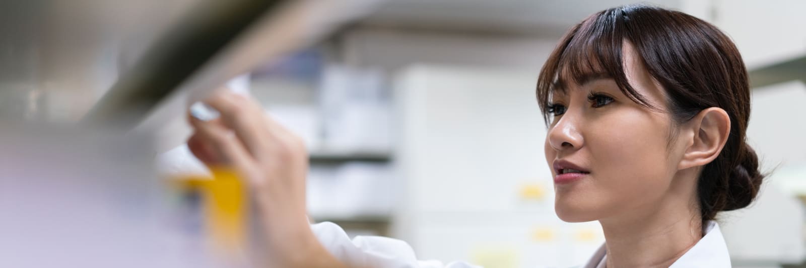 close up of female pharmacist stocking a shelf