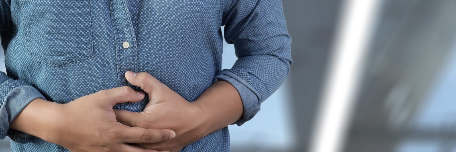 man with hernia symptoms holding his abdomen