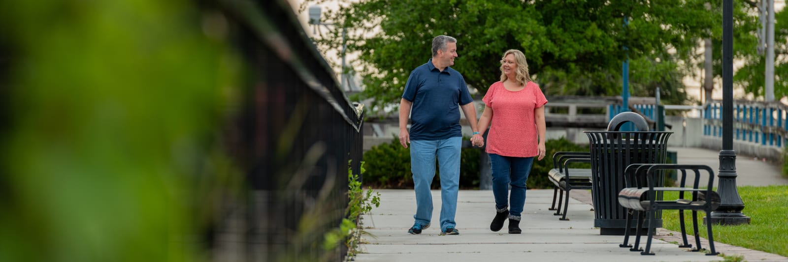 A Jacksonville couple strolls on a sidewalk holding hands after both finding bariatric surgery as a long-term weight loss solution.