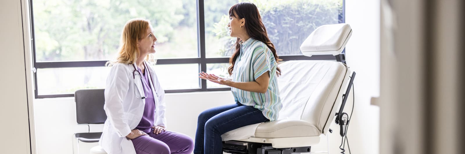 A female patient and a gynecological surgeon talking in an exam room