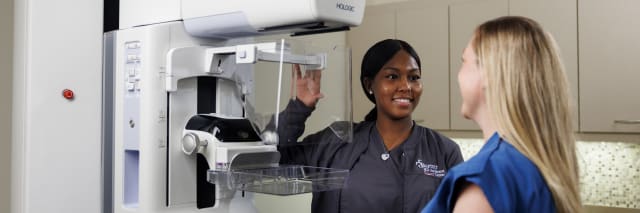 medical worker assisting woman getting a mammogram