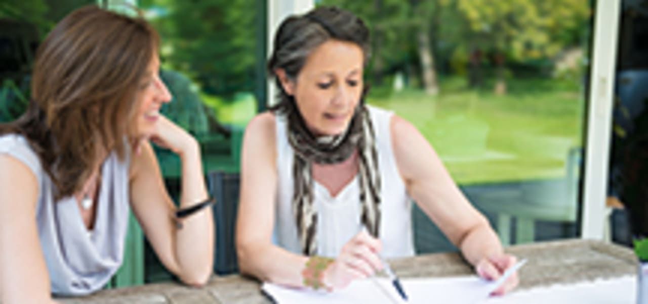 woman walks through paperwork with female patient
