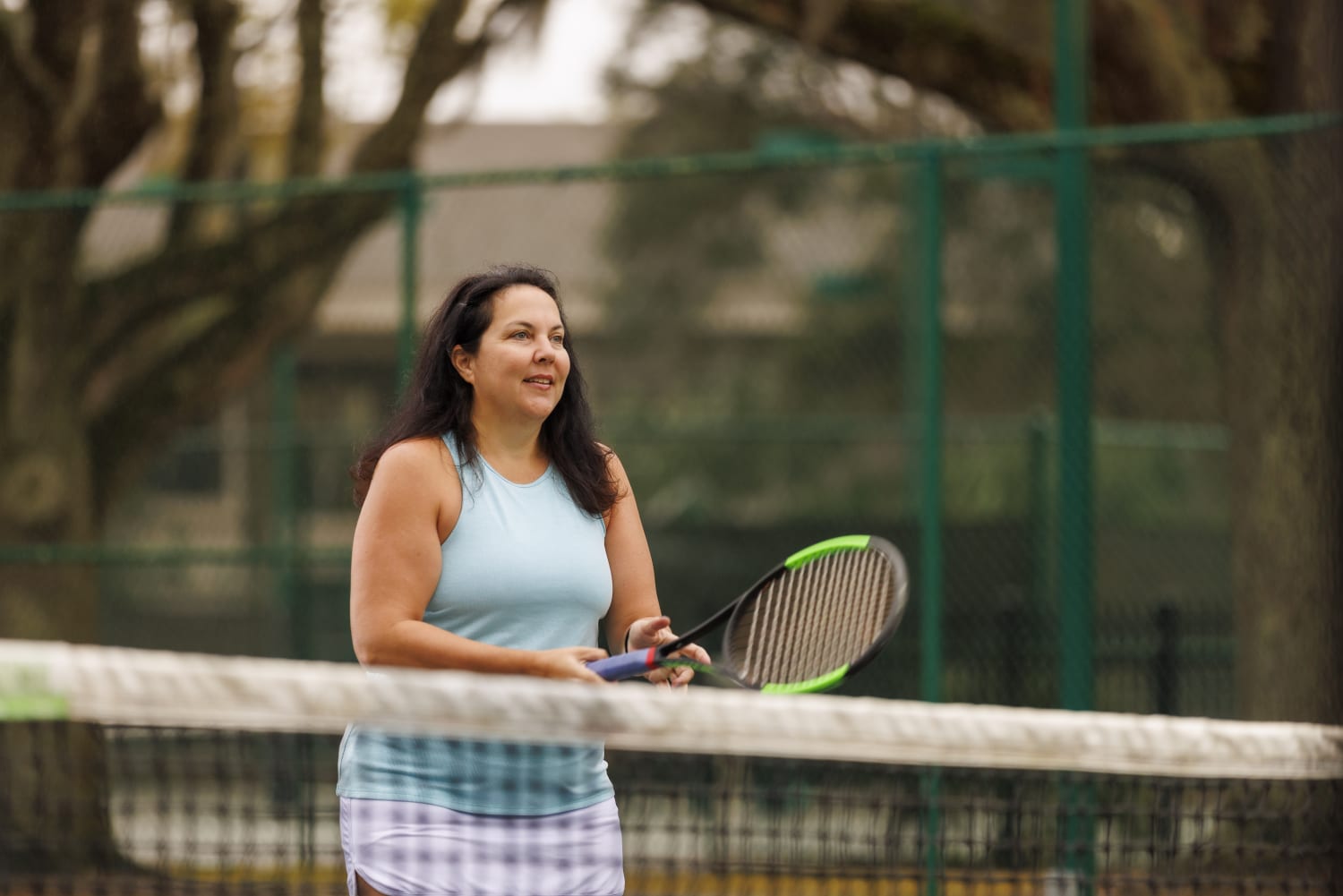 a healthy woman plays tennis after finding a long-term weight loss solution -- bariatric surgery