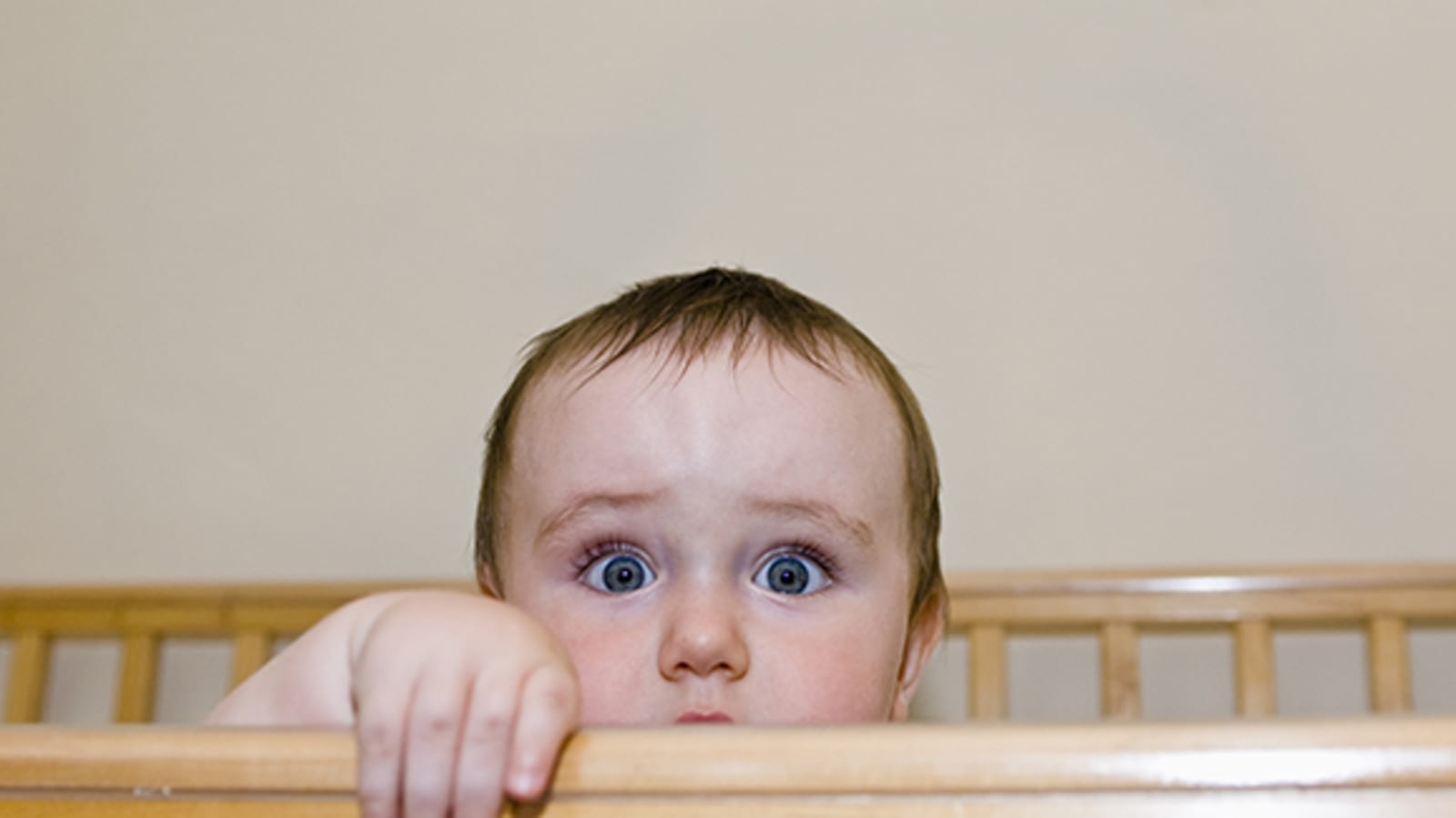 A baby looks at the camera wide-eyed.