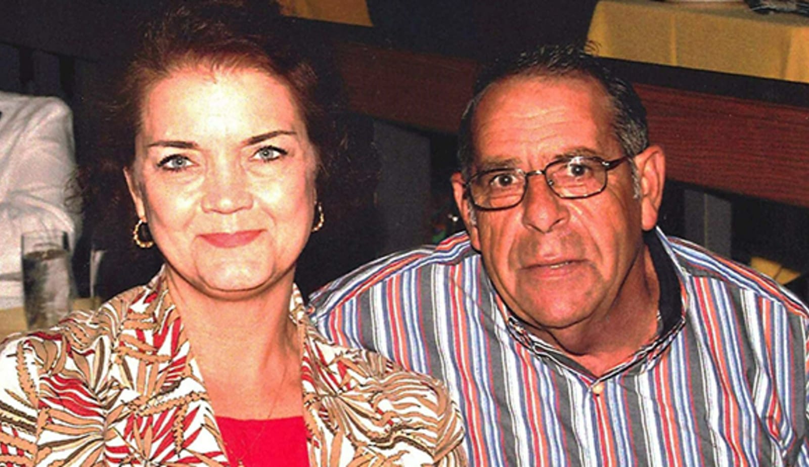photo of wife and husband, Susan and Jim Taylor, sitting together in a restaurant, smiling