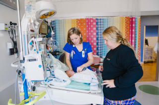 a nurse lovingly caring for a newborn baby in the nicu