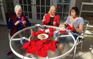 women crocheting outside together