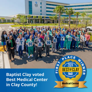 A group of Baptist Health employees standing in front of the Baptist Clay building with text overlay that says "Baptist Clay voted Best Medical Center in Clay County!"