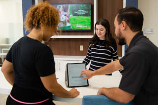 group of wellness coaches meeting registering a woman at the front desk